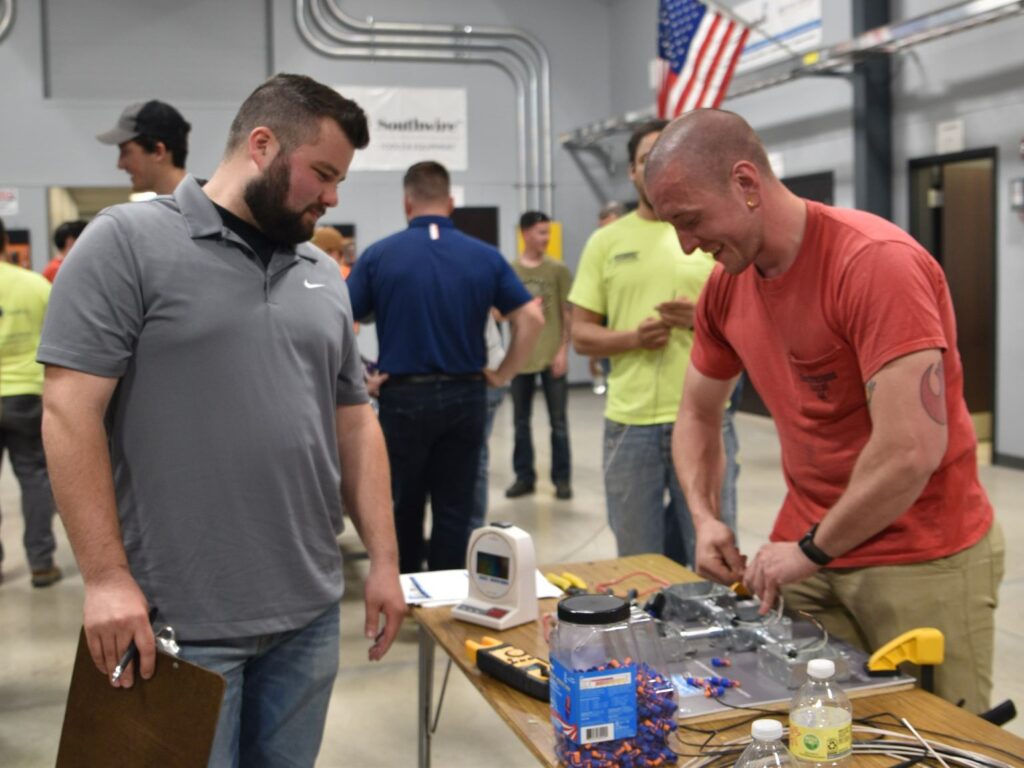 An electric apprentice competes in a competition.