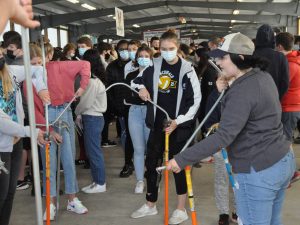 Students try bending conduit at a trades expo.