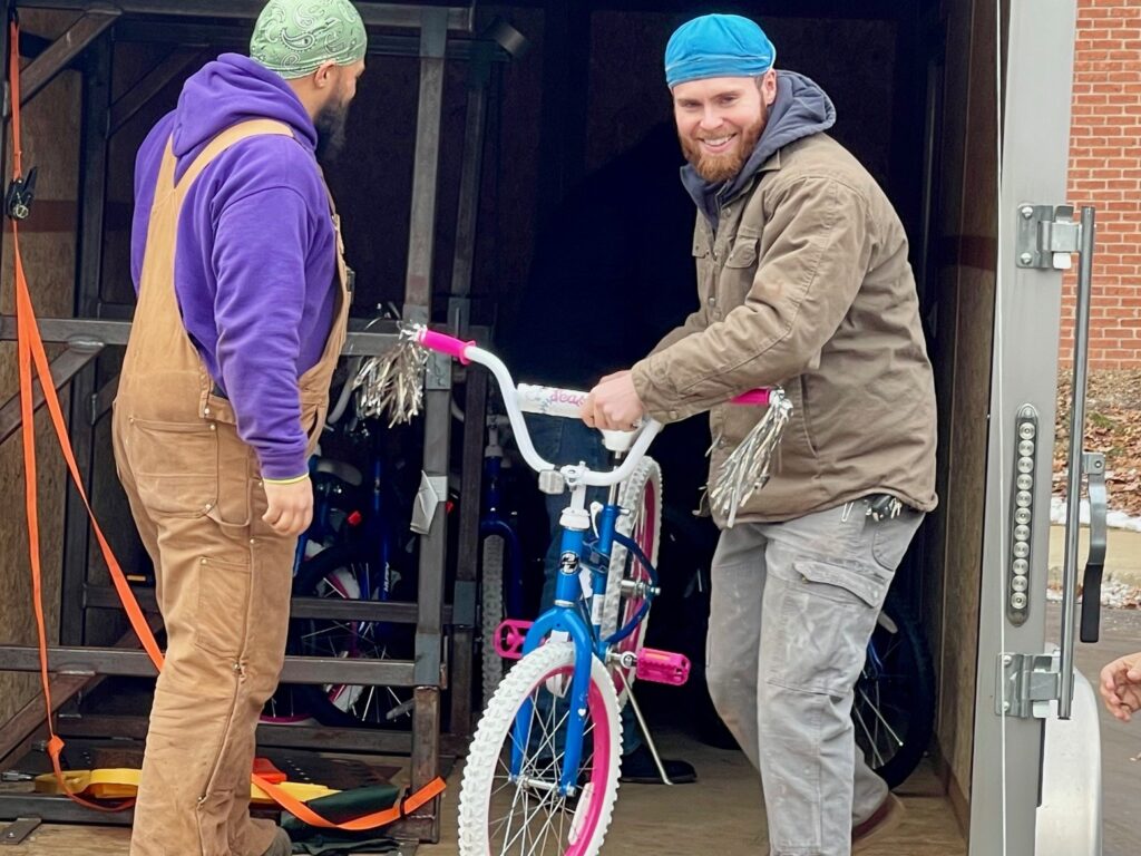 IBEW Local 573 apprentices Sean Duckworth and Wyatt Baer unload bikes at Trumbull County Children Services.