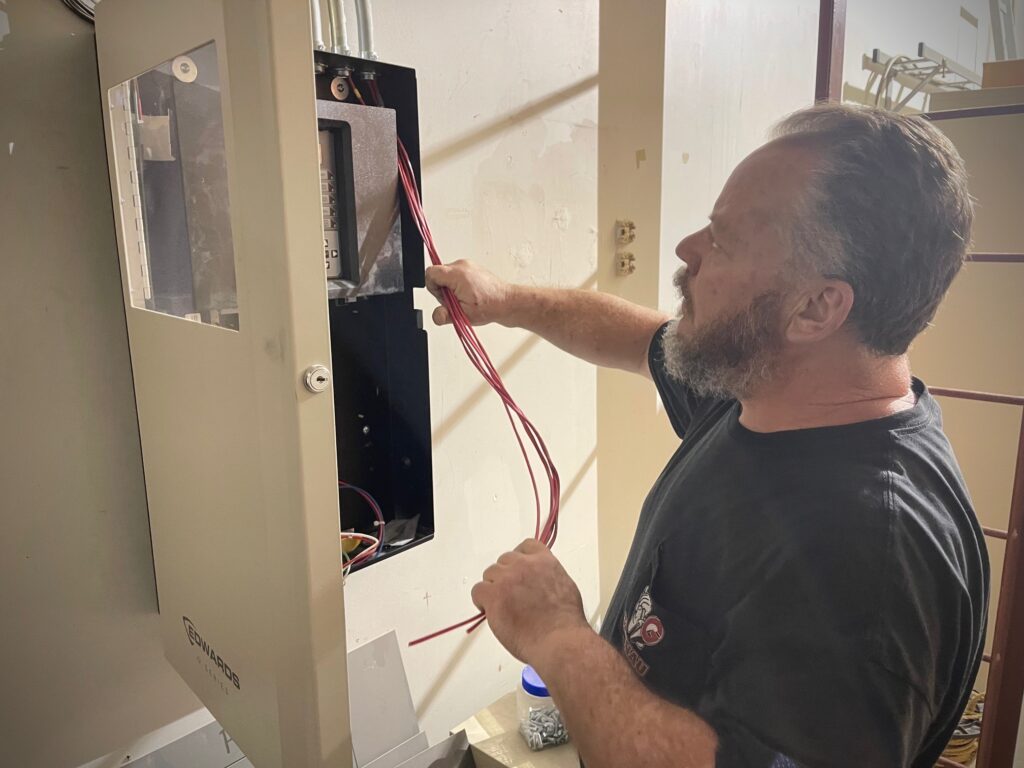 Bob Mass, journeyman at MG Electric, pulls in the wiring for the fire alarm system for the new Mahoning County Veterans Service Commission.