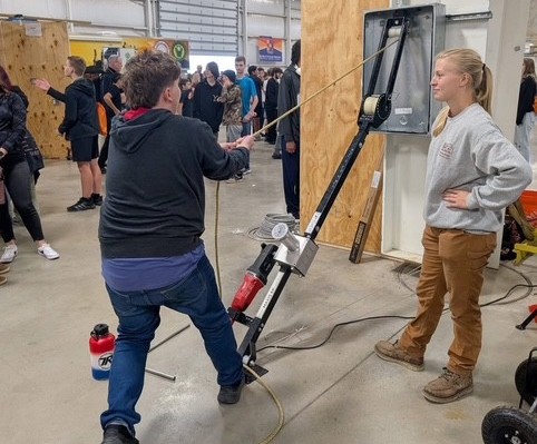 Alexis Sperling, apprentice, with student at wire pulling demonstration at the Mahoning Valley Skilled Trades Expo.