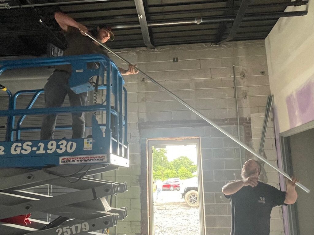 Isaac Arnold and Bob Mass with conduit at the Mahoning County Veterans Service Commission building which will be opening in late 2025.