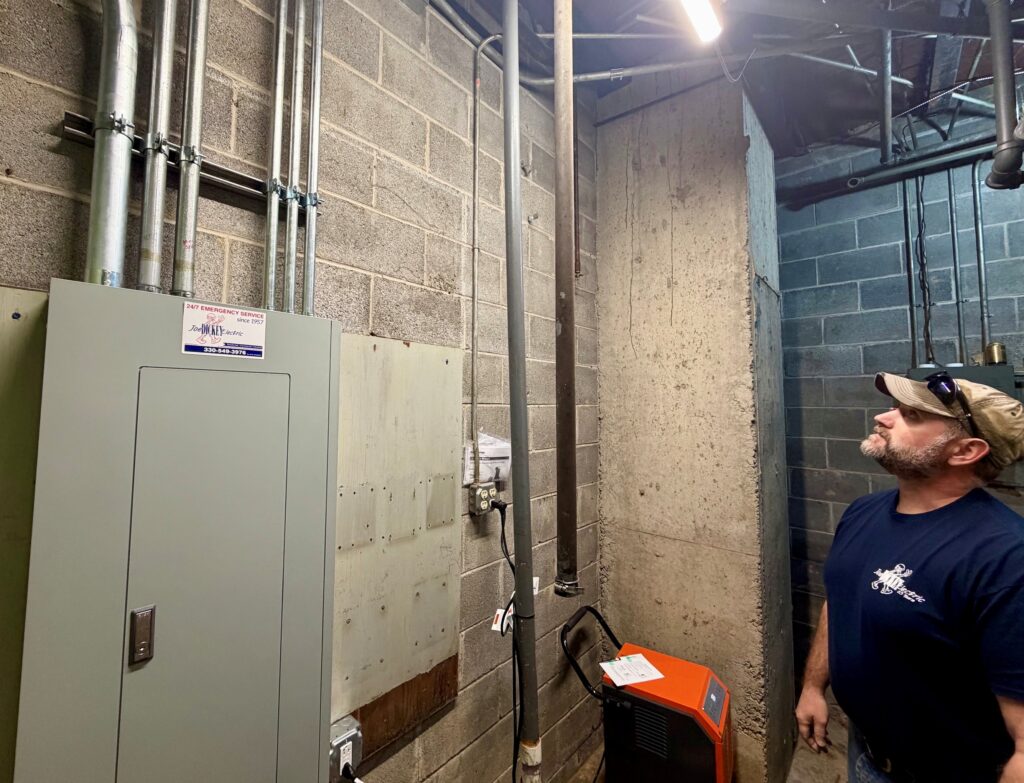 Jon Herchik, foreman at Dickey Electric, and new distribution panel that replaced an old one at Westside Bowl.
