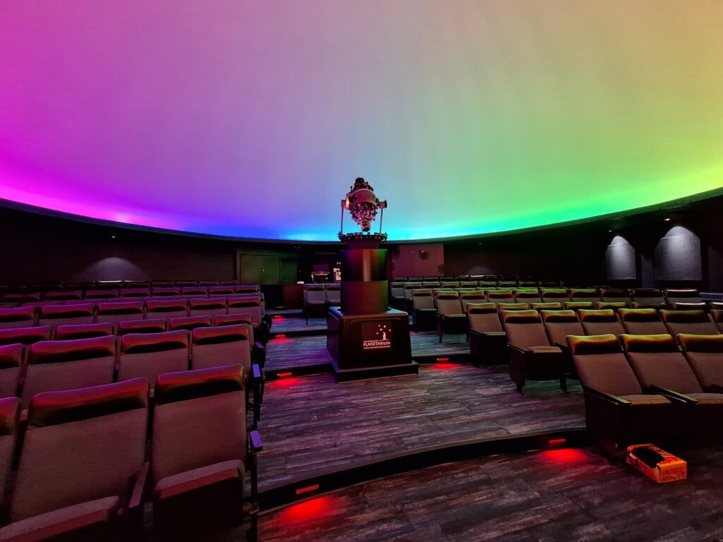 The planetarium has colorful lighting options and can project video onto the dome. Red, dimmable lighting was installed on the theater-style steps for safety.