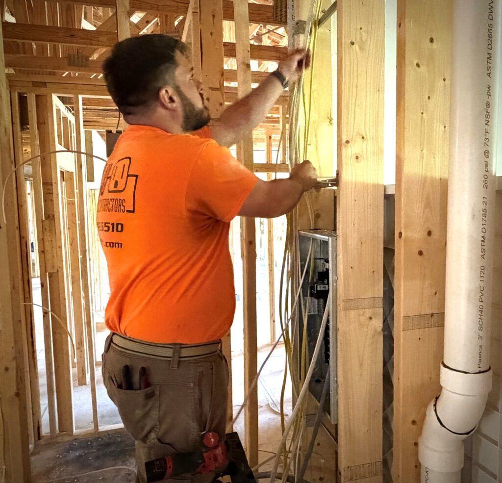 Chris Platton running wire to electrical panel.