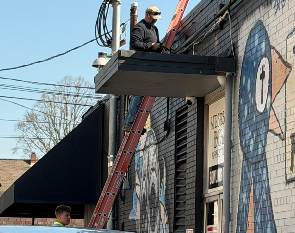 Jon Herchik and Owen Elliot, of Dickey Electric, working outside Westside Bowl in Youngstown. Part of the work involved HVAC units on the roof.