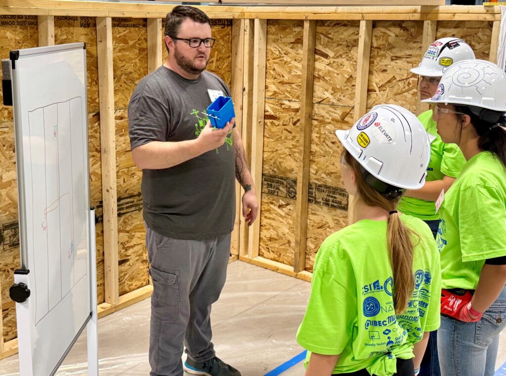 Ahren Peplow, Youngstown Area Electrical JATC training director, explains electrical project to  students participating in Let's Build Construction Careers Camp.