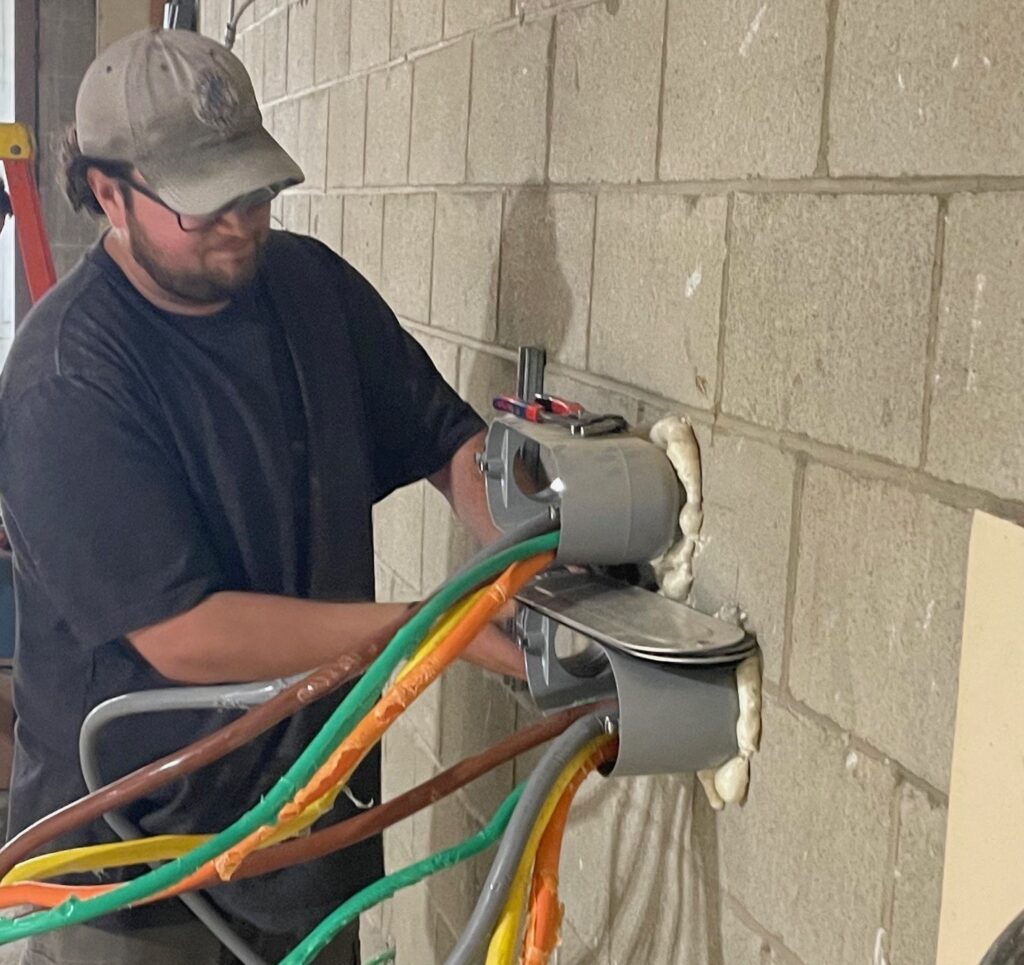 Mike Ferradino, apprentice with CR Electric, working on the main wiring area for the Grocery Outlet.