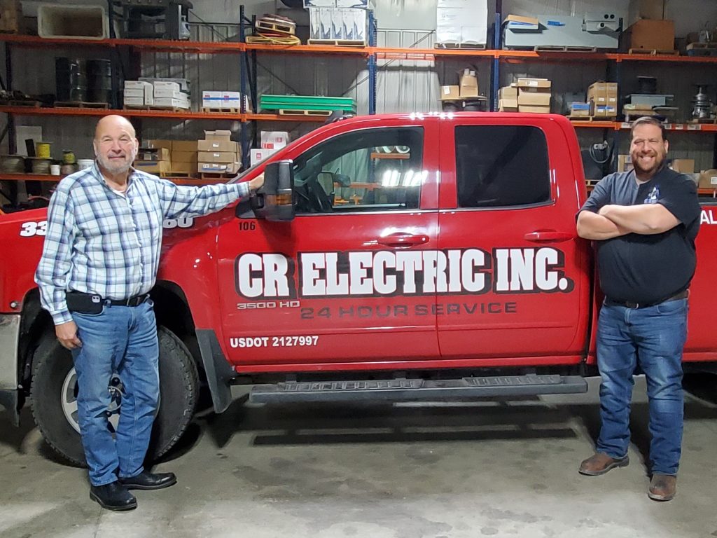 Marc Rubin, left and son Jason stand in front of a CR Electric company vehicle.