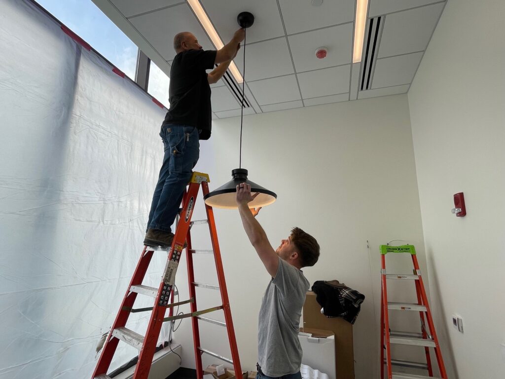 Dave McGoogan and Tom Plummer, of Dickey Electric, installing light fixture inside Chase Bank in downtown Youngstown.