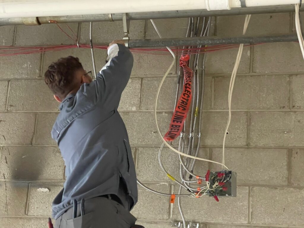 Patrick Sturgeon, journeyman with CR Electric, disconnecting old wires that won't be used anymore.