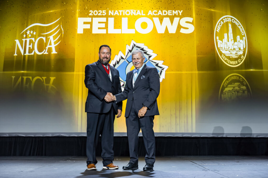 Eric Carlson, president and owner of Dickey Electric, on stage at the NECA conference with NECA Academy Chairman David Hardt.