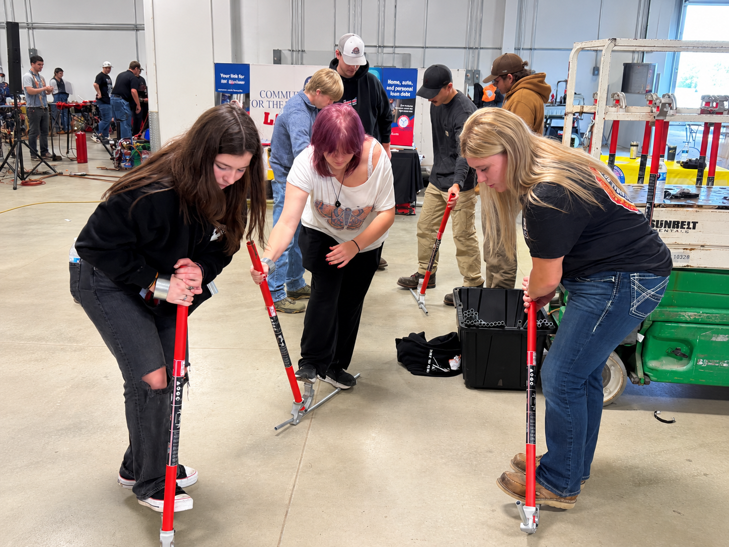 Lillian Davis, IBEW Local 573 apprentice, with students demonstrating conduit bending.