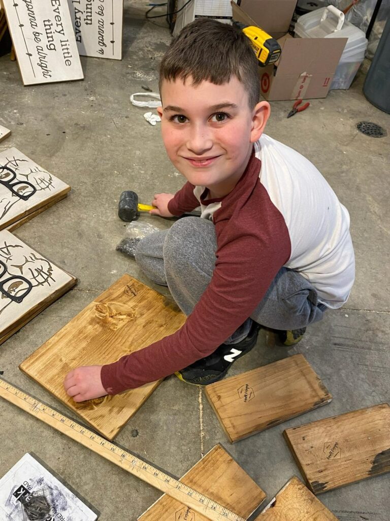 Austin Lucas, 9, works on a sign for his family business, A and R Design. 