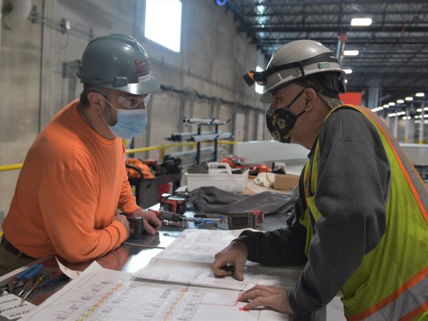 Electricians discuss a task at TJX.