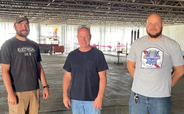 Marcus Durig, Jerry Kagy, and Jeff Mendenhal (left to right), of TSquared Electrical inside building to be Caliber Collision in Struthers.