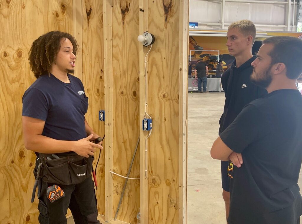 Michon Peterson, journeyman electrician, talks with students at the Mahoning Valley Skilled Trades Expo in September 2024.