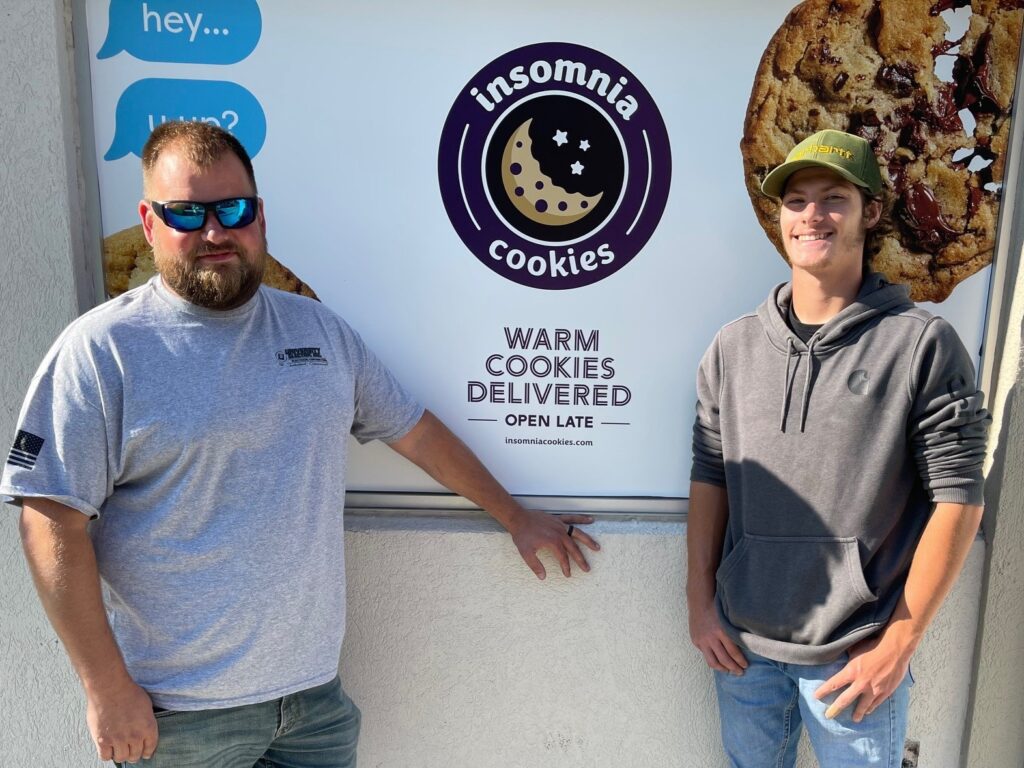 Mike Engle (left) and Ivan Lindberg outside Insomnia Cookie on the YSU campus. They did the electrical work for the location.