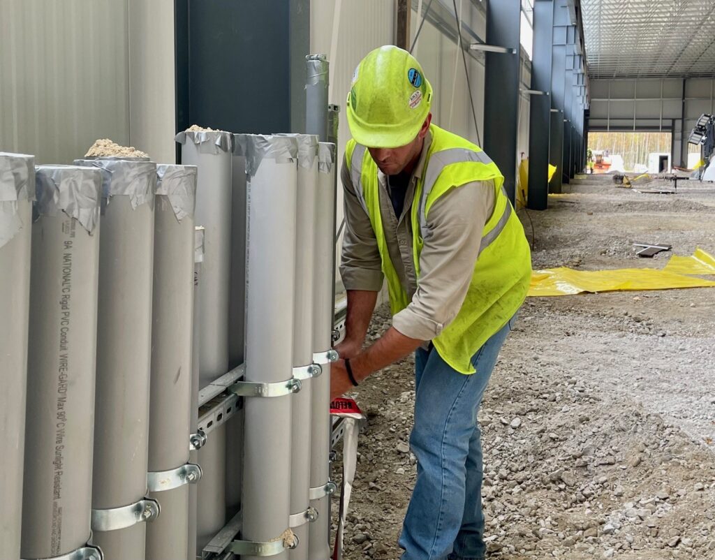 Nick Clemmer, project manager at Liberty Electric, adjusts burial tape at main conduit lines at Cleveland Steel Container.