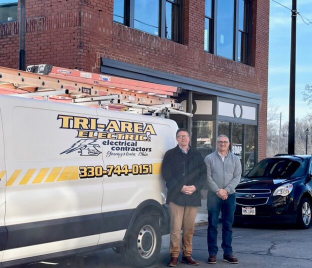 Greg Hann and Joe DeLullo standing with Tri-Area Electric van outside Rica Building in Youngstown