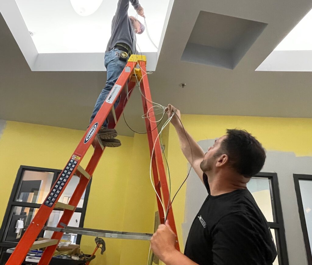 Rob Mistovich, foreman at MG Electric, with apprentice, Isaac Arnold, pulling wire for lighting inside Youngstown Business Incubator.
