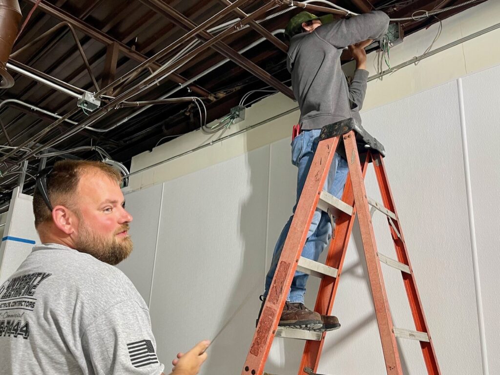 Mike Engle and Ivan Lindberg, of University Electric, pulling new wiring for Insomnia Cookies.